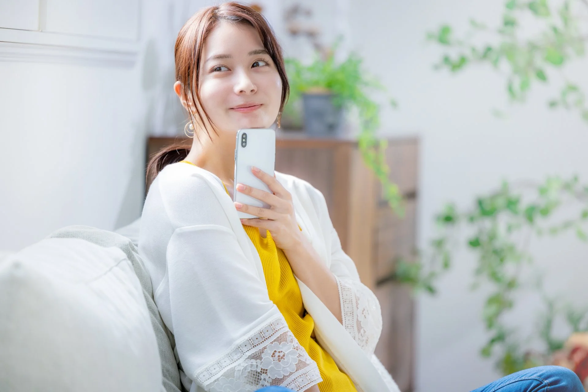 スマートフォンを手にほほえむ女性